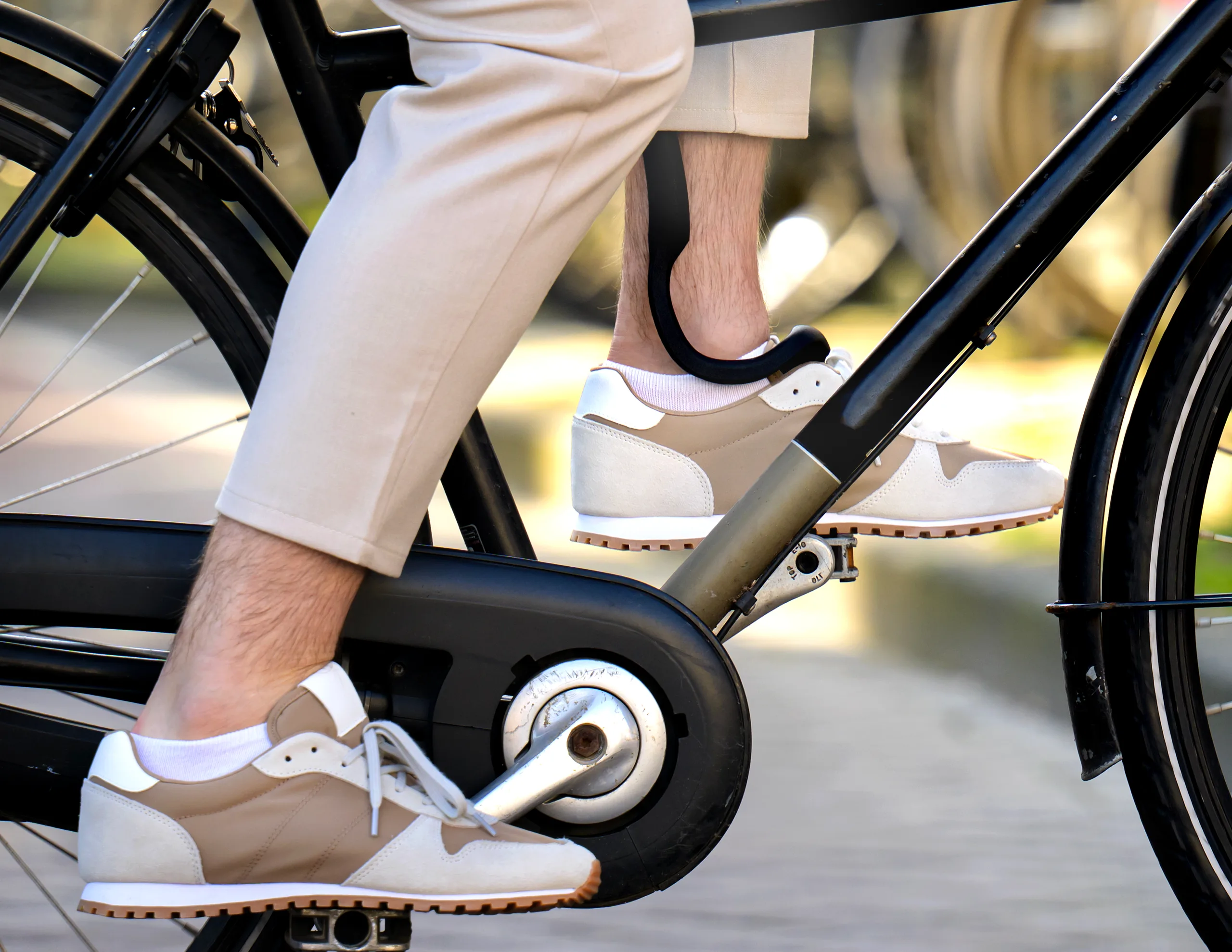 A close-up of someone cycling, The Rise visible on the ankle — light enough for everyday wear
